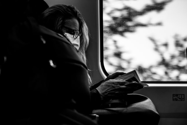Woman on the train reading one of the 10 great books for travelers this winter