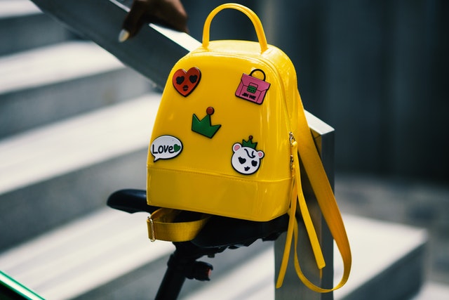 A yellow backpack with stickers.