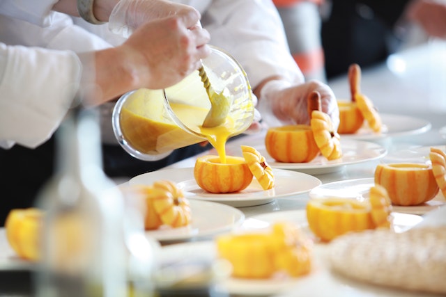 pumpkin soup being poured into small pumpkins