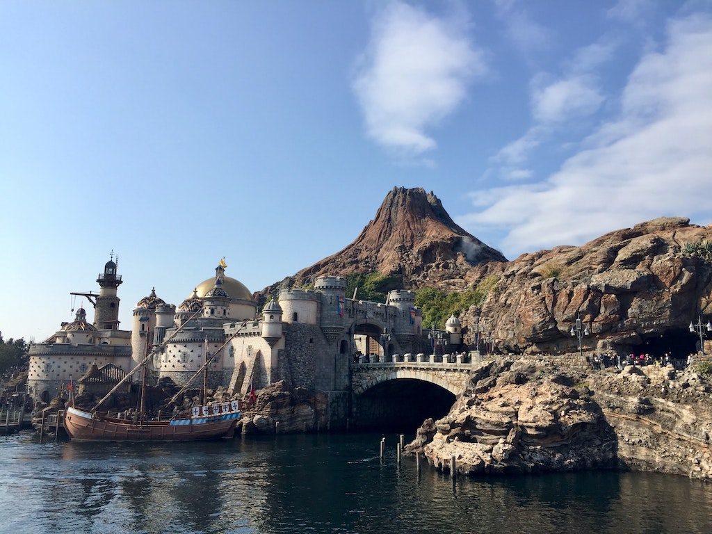 A scene in a theme park featuring a fortress on the water