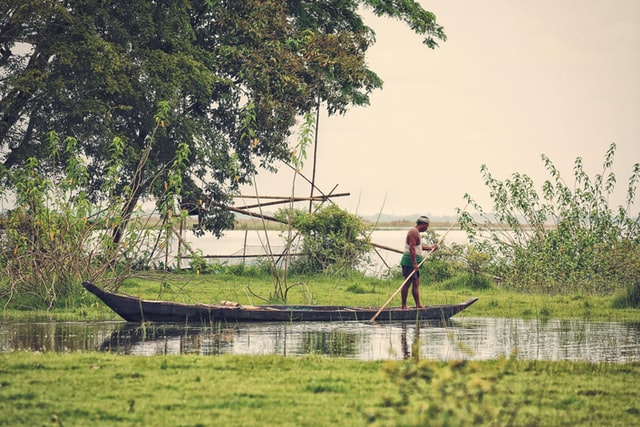 Photo of a man standing on a boat as a featured image for a post about the best places to visit in Northeast India
