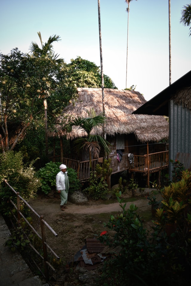 Photo of a man walking next to a traditional house in Mawlynnong village in Northeast India