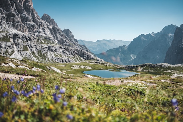A lake with rocky mountains depicts the best places to visit in Europe this summer.