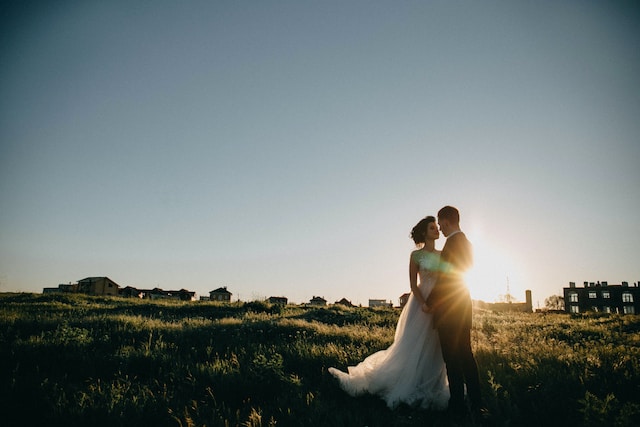 a wedding couple looking at each other on a meadow