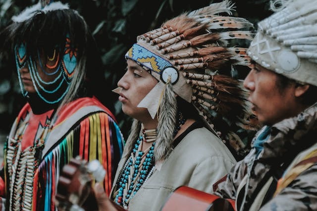Three men dressed in traditional Native American clothes