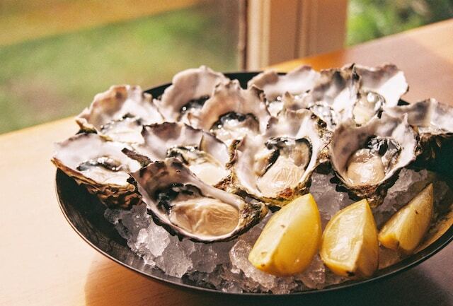 A plate of oysters with some lemons