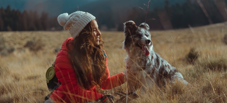 A girl and a dog traveling together.